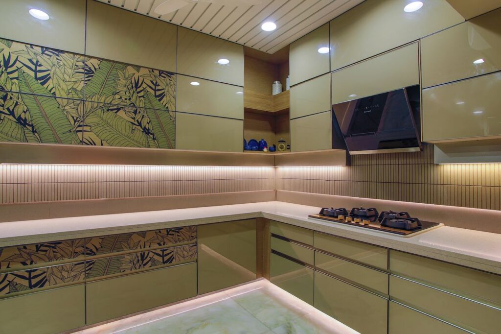 Sleek kitchen design featuring green cabinets, hob, and floral accents.