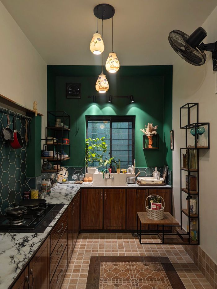 Cozy modern kitchen featuring marble countertops, wooden cabinets, and artistic lighting.
